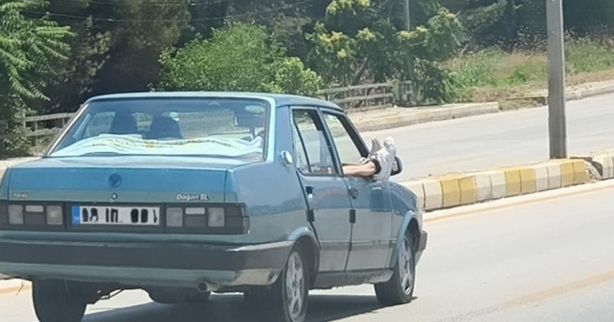 Ayaklarını camdan dışarı çıkartan yolcu trafiği riske attı